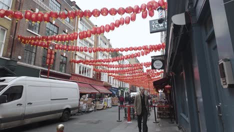 Chinatown-Gerrard-Street-In-London-Mit-Roten-Laternen,-Die-über-Dem-Kopf-Schwingen,-Während-Ein-Weißer-Lieferwagen-Vorbeifährt