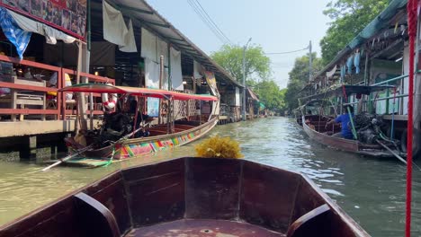 Navegando-En-Canoa-De-Madera-A-Través-De-Canales-De-Agua-De-Un-Mercado-Flotante-En-Bangkok