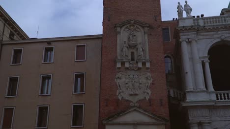 Nahaufnahme-Einer-Langsamen-Neigungsaufnahme-Eines-Wunderschönen-Alten-Italienischen-Gebäudes-Und-Turms-In-Vicenza,-Italien