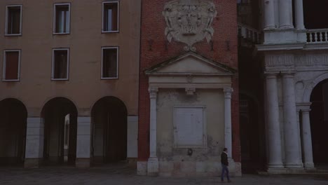 Vista-Fija-De-Una-Persona-Caminando-Por-Un-Hermoso-Y-Antiguo-Edificio-Italiano-En-Vicenza,-Italia.