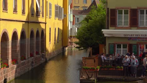 La-Gente-Admira-Las-Típicas-Casas-Con-Entramado-De-Madera-Alsaciano-A-Lo-Largo-De-Las-Orillas-Del-Río-En-El-Distrito-De-La-Petite-Venise-De-La-Ciudad-De-Colmar.