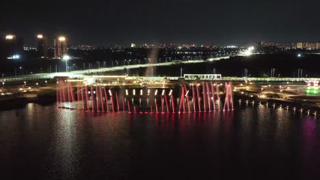 Establishing-Shots-drone-camera-is-moving-forward-where-a-colorful-fountain-is-happening-and-many-people-are-watching