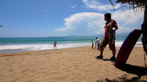 Woman-running-out-of-the-water-up-to-a-child-and-wake-border-on-Ixtapa-Beach