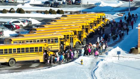 Grundschüler-Besteigen-Gelbe-Schulbusse-Während-Der-Vorzeitigen-Schulschluss-Wegen-Schneewetter