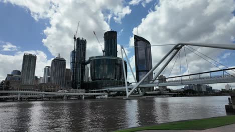 Blick-Auf-Die-Skyline-Der-Stadt-Mit-Im-Bau-Befindlichen-Gebäuden-Und-Einer-Fußgängerbrücke-über-Einen-Fluss-In-Einer-Großen-Stadt-In-Australien