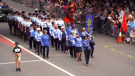 Airwomen-from-Royal-Australian-Air-Force-Association-uniformly-marching-down-the-street-in-Brisbane-city,-amidst-the-solemnity-of-the-Anzac-Day-commemoration-with-cheering-crowds-lined-the-street