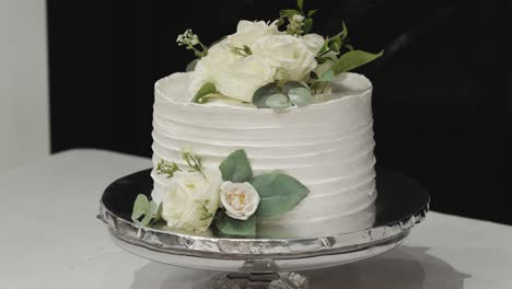 Wedding-cake-made-of-white-fondant,-decorated-with-small-natural-flowers