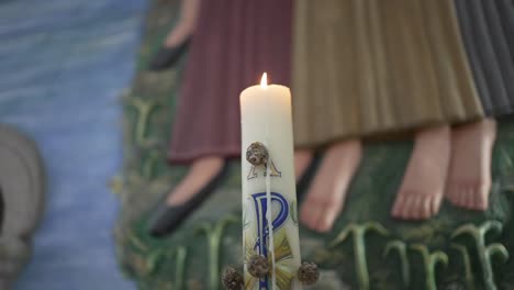 Lit-paschal-candle-with-alpha-and-omega