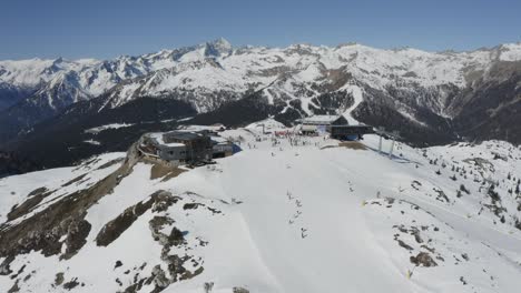 Skiers-enjoy-magnificent-Dolomite-winter-scenery,-Madonna-di-Campiglio-gondola-lift-station