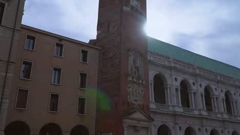 Vista-De-Un-Hermoso-Y-Antiguo-Edificio-Italiano-Y-Una-Torre-En-Vicenza,-Italia,-Filmada-Con-Un-Movimiento-De-Cámara-Inclinada