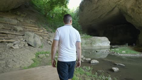 A-Man-Is-Walking-Towards-God's-Bridge,-A-Natural-Stone-Arches-Near-Vratsa-In-Bulgaria