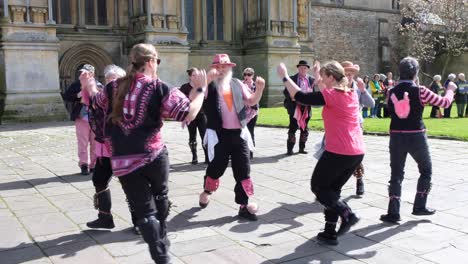 Cultural-morris-dancers-performing-and-practising-a-traditional-English-folk-dance-outside-Wells-Cathedral-in-Somerset,-UK