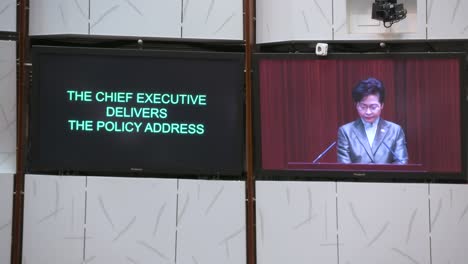 Carrie-Lam,-Ex-Directora-Ejecutiva-De-Hong-Kong,-Aparece-En-La-Pantalla-De-La-Cámara-Principal-Mientras-Pronuncia-El-Discurso-Político-Anual-En-El-Edificio-Del-Consejo-Legislativo.