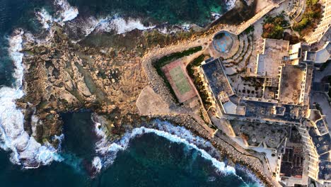 Top-down-Drone-shot-of-Abandoned-Jerma-Palace-Hotel-in-Marsaskala,-sunrise-time,-Malta