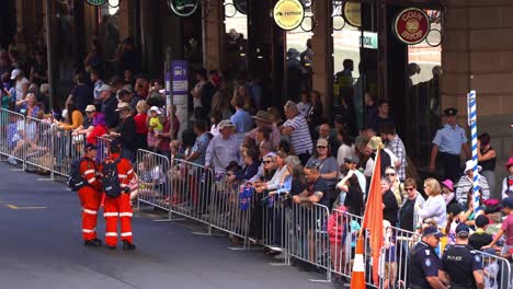 Volunteer-from-the-Queensland-State-Emergency-Service-assisting-with-crowd-control-at-the-annual-Anzac-Day-parade,-ensuring-safety-and-order-of-the-public