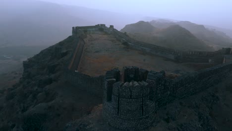 Aerial-View-Stone-Bulwark-At-Ranikot-Fort-With-Foggy-Mist-Floating-In-the-Air