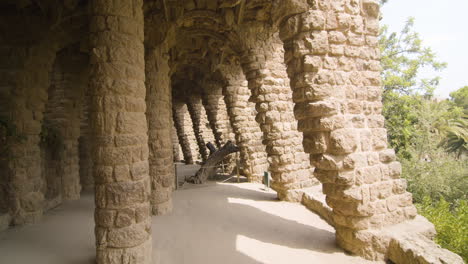 Walking-through-Park-Guell-under-a-path-of-arcades-and-stone-columns