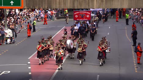 Nationale-Militärkapelle,-Dudelsackspieler-Und-Trommler-In-Traditioneller-Kleidung,-Spielen-Dudelsäcke-Und-Trommeln-Für-Die-Stadt-Brisbane-Während-Der-Jährlichen-Tradition-Der-Anzac-Day-Parade