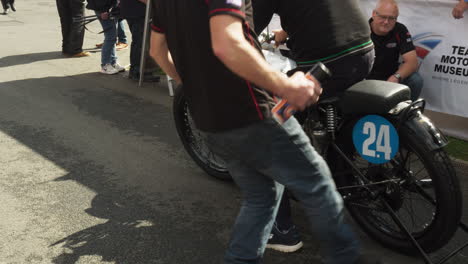 La-Tripulación-Atiende-Una-Bicicleta-De-Carreras-Antigua-En-Boxes-Durante-El-Gran-Premio.