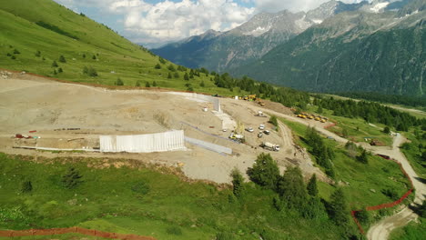 Top-down-aerial-drone-shot-of-a-dam-construction-site-in-the-alpine-mountains