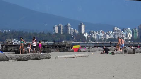 Vancouver-city-skyline-with-seaplane-landing-and-mountain-views-and-muscle-men-on-beach