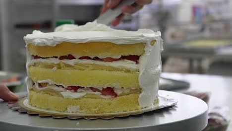 Watch-the-cake-come-to-life:-close-up-shot-captures-a-hand-skillfully-applying-fondant-on-a-delectable-cake