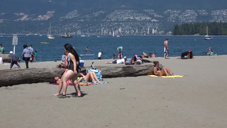 Kitsilano-Beach-Mit-Stanley-Park-Im-Hintergrund-Mit-Bikinis-Und-Spaziergängern-Am-Strand