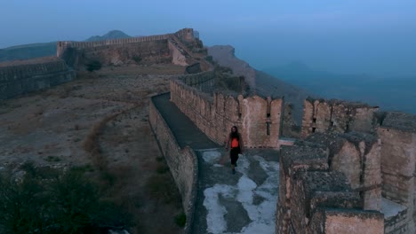 Vista-Aérea-De-Una-Persona-Caminando-A-Lo-Largo-Del-Muro-De-Defensa-En-El-Fuerte-Ranikot.