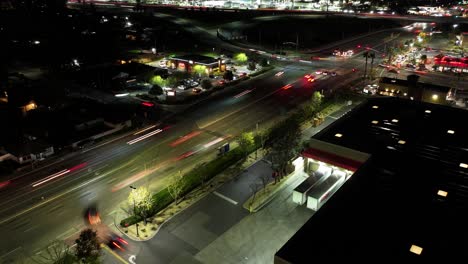 Nacht-Zeitraffer-Der-Auf--Und-Abfahrt-Auf-Dem-California-Highway-10,-Dem-Redlands-Freeway,-Der-In-Die-South-Tippecanoe-Avenue-In-San-Bernardino-übergeht.-Starker-Verkehr,-Lange-Belichtung,-Scheinwerfer,-Luftaufnahme,-LKW-Transport,-Schwenk-Nach-Links