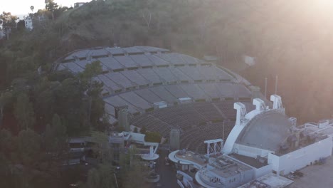 Low-panning-aerial-shot-of-the-Hollywood-Bowl-at-sunset-with-lens-flare-in-Los-Angeles,-California