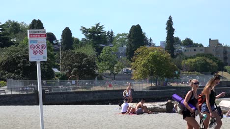 Las-Adolescentes-Caminando-Por-Una-Playa-Con-Bañistas