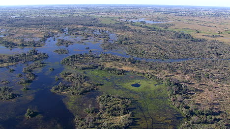 Extreme-wide-shot-of-the-Okavango-Delta-in-Botswana,-zooming-in-to-a-closer-shot-of-a-tourist-game-drive-vehicle