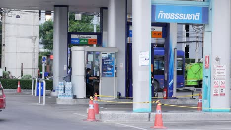 Red-car-moving-backwards-at-a-gas-station-located-near-a-busy-street-in-the-city-of-Bangkok-in-Thailand