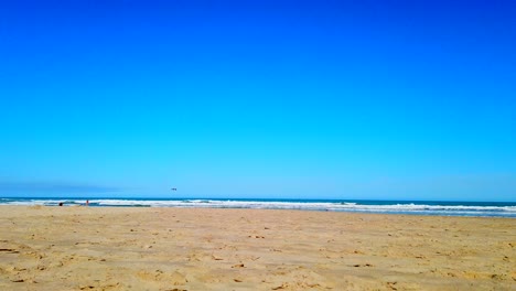 Den-Wellen-Lauschen-Und-Mit-Sand-Am-Strand-Unter-Der-Mittagssonne-Und-Dem-Blauen-Himmel-Spielen