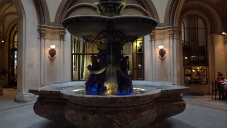 Fountain-Lit-With-Blue-and-Yellow-Colours-in-Ferstel-Passage