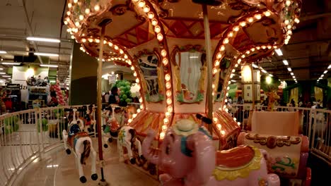 Kids-enjoying-ride-in-a-Merry-go-around-located-at-the-kids-zone-inside-a-shopping-mall