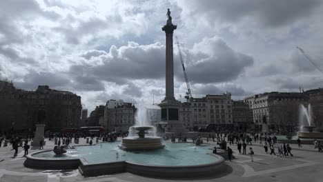 Brunnen-Und-Nelsonsäule-Gegen-Sonnigen-Bewölkten-Himmel-Im-überfüllten-Trafalgar-Square,-Westminster,-London,-Großbritannien