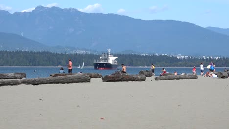 Un-Gran-Barco-Al-Fondo-Con-Una-Vista-De-Todo-El-Parque-Stanley-También,-Visto-Desde-La-Playa-De-Locarno-En-Vancouver