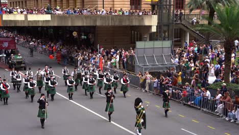 Studenten-Der-Dudelsackkapelle-Des-Brisbane-Boys&#39;-College-In-Traditioneller-Kleidung-Spielen-Dudelsäcke-Und-Trommeln-Für-Die-Stadt-Brisbane-Während-Der-Jährlichen-Tradition-Der-Anzac-Day-Parade-Mit-Jubelnden-Menschenmengen-Entlang-Der-Straße