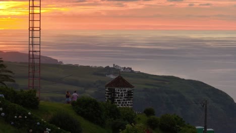 Tourists-enjoy-stunning-sunset-view-over-Atlantic-from-Vigia-das-Baleias,-aerial