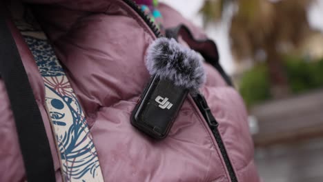 DJI-Wireless-Mic-2-Mit-Flauschiger-Deadcat-Oben-Drauf,-Befestigt-An-Einer-Rosa-Jacke