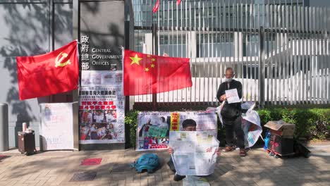 Demonstranten-Stehen-Neben-Den-Flaggen-Der-Volksrepublik-China-Und-Der-Kommunistischen-Partei-Chinas-Vor-Den-Büros-Der-Zentralregierung-Und-Dem-Gebäudekomplex-Des-Legislativrats-In-Hongkong