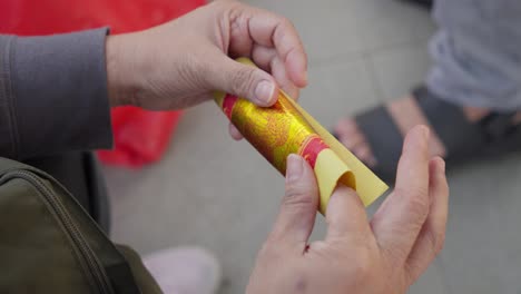 Hands-Fold-joss-incense-paper-to-burn-for-Cheng-Beng-Festival-Chinese-honoring-dead-ancestors-Closeup-shot