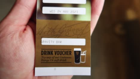 Hand-Hält-Einen-Getränkegutschein-Für-Ein-Guinness-Bier-In-Der-Gravity-Bar