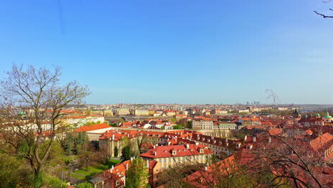 Panoramic-cityscape-of-historic-old-Czech-republic-Prague-town-skyline-autumn-sunlight-above-european-travel-capital-destination,-dry-trees-,-red-roofs-architecture,-houses