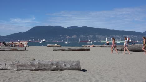 Young-women-at-beach-in-summer,-ships-in-background