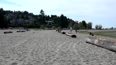 Pareja-Caminando-En-La-Playa-De-Locarno,-Vistas-Al-Mar-De-La-Bahía-Inglesa-En-Vancouver