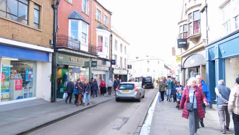 Busy-high-streets-with-people-shopping-at-local-retail-shops-and-businesses-over-Easter-Weekend-in-historic-city,-Southwest-of-England,-UK