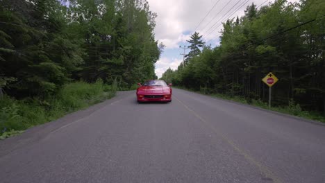 Ferrari-355gts-Rojo-Conduciendo-Por-Una-Carretera-Rural---Tiro-Bajo-Delantero