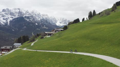Atletas-De-Bicicleta-De-Montaña-Entrenan-En-El-Espectacular-Paisaje-Primaveral-De-Los-Dolomitas,-Drones